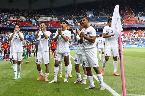Uzbekistan players react to their supporters after match against Spain